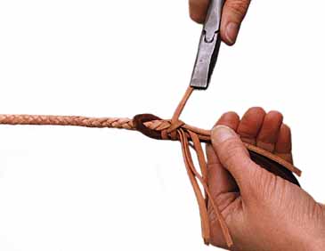 Move the remaining strands to the left, leaving any core strands against the fall, and fold the end of the first strand down and hold it against the fall. Taking a second strand pull it tight and tie a second half hitch in the same manner as the first.