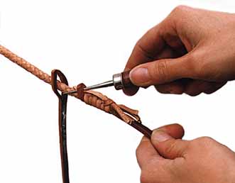Attach the main body of the whip to a hook or some other secure anchor, then trim the end of the new fall to a point, put the old fall and part of the thong through the eye of the new fall and grease the new fall with braiding soap or Pecard Leather Dressing